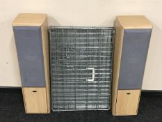 A pair of Eltak floor speakers and a folding dog cage