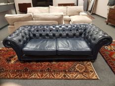 A blue buttoned leather Chesterfield style three seater settee, length 230 cm.