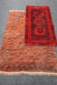 A fringed Afghan Bokhara rug on red ground,