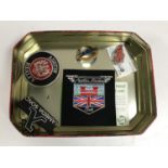 A tin of London Transport badge number 452, two Austin Healey sew on patches,