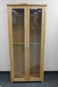 A double door contemporary beech display cabinet with glass shelves