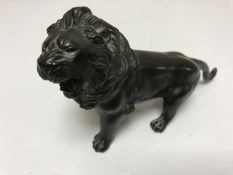 A nineteenth century Chinese bronze figure of a lion, with character marks to base, length 12 cm.