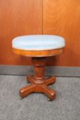 An antique oak adjustable stool on castors