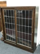 An oak double door sliding leaded glass door bookcase