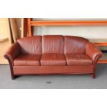 A Danish stained beech framed three seater settee in brown leather