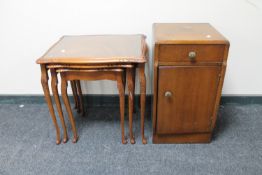 A nest of three mahogany glass topped tables together with an oak pot cupboard