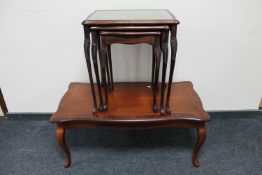 A mahogany coffee table together with a nest of three mahogany glass and leather top tables