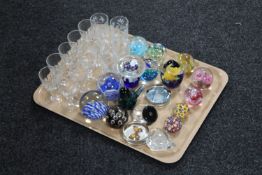 A tray containing a collection of assorted glass paperweights and a small quantity of drinking