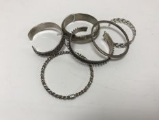 Six sterling silver and white metal bangles.