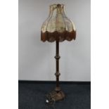 An antique oak standard lamp with an animal hide shade