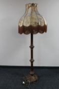 An antique oak standard lamp with an animal hide shade