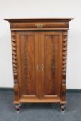 A mahogany double door cabinet fitted a drawer