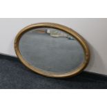 An antique oval gilt framed bevelled mirror