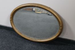 An antique oval gilt framed bevelled mirror