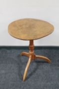 A circular tilt top pedestal occasional table