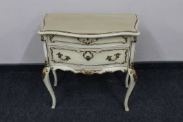 A French cream and gilt two drawer chest on cabriole legs