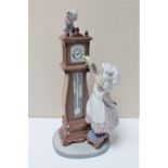 A Lladro figure of a girl and a grandfather clock