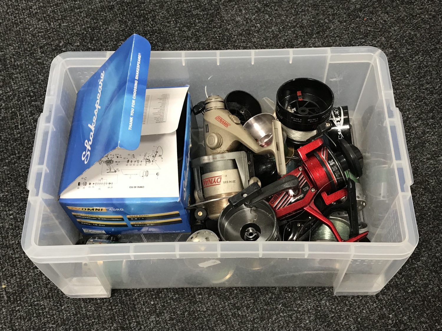 A box containing assorted fishing reels