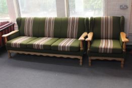 A blonde oak framed three seater settee and armchair in green striped fabric