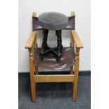 An oak leather slung upholstered armchair together with a pub stool