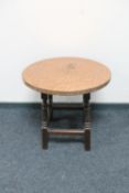 A circular copper topped table on oak base