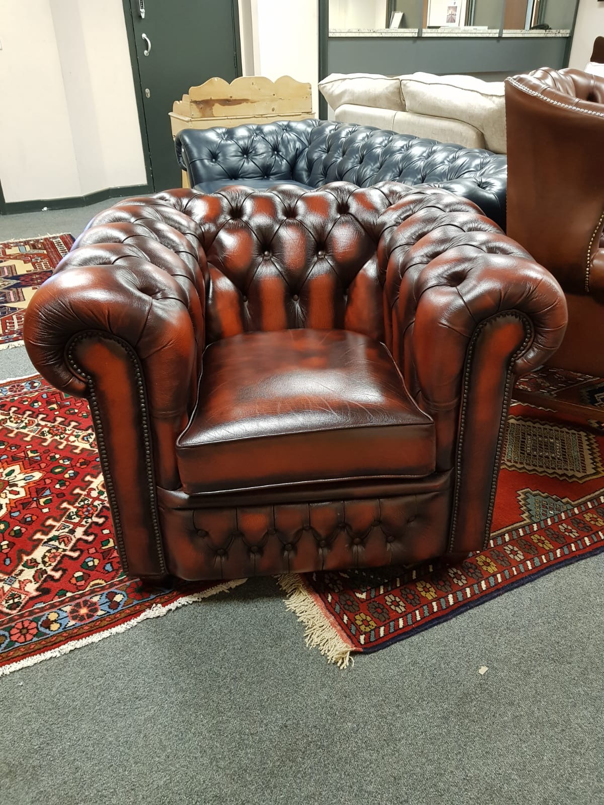 An oxblood buttoned leather Chesterfield style club chair,