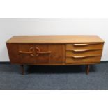 A mid 20th century teak double door sideboard fitted three drawers