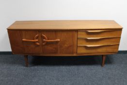 A mid 20th century teak double door sideboard fitted three drawers