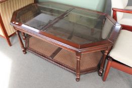 An octagonal mahogany coffee table with inset glass panels