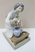 A Lladro figure of a lady in Japanese dress arranging flowers