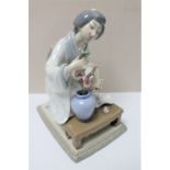 A Lladro figure of a lady in Japanese dress arranging flowers