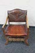An early 20th century oak armchair upholstered in leather