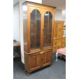 An Edwardian oak double door glazed bookcase fitted cupboard beneath