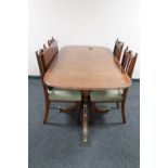 An inlaid mahogany Regency style twin pedestal dining table with leaf together with a set of four