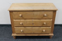 A stripped pine three drawer chest