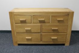 A contemporary oak seven drawer chest