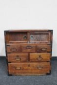 A Chinese style pine cabinet fitted a cupboard and seven drawers