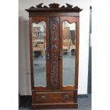 An Edwardian mahogany double door mirrored wardrobe fitted a drawer beneath