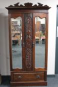 An Edwardian mahogany double door mirrored wardrobe fitted a drawer beneath