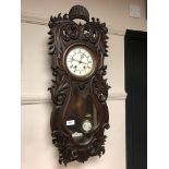 A Victorian carved beech wall clock with enamelled dial