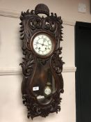 A Victorian carved beech wall clock with enamelled dial