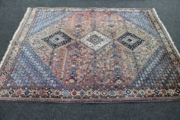 A fringed woolen hand made Persian rug of geometric design on blue ground,