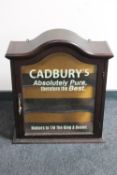 A mahogany arched topped wall cabinet bearing advertisement
