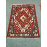 A Persian rug on red ground,