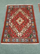 A Persian rug on red ground,