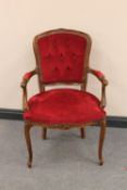 A continental beech framed salon armchair upholstered in red dralon