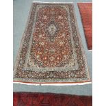 A Kashan carpet on red ground,