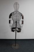 A wire metal female mannequin torso on stand