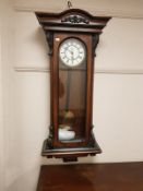 A Victorian mahogany wall clock with enamelled dial, with pendulum and heights,