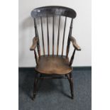 An antique elm kitchen armchair